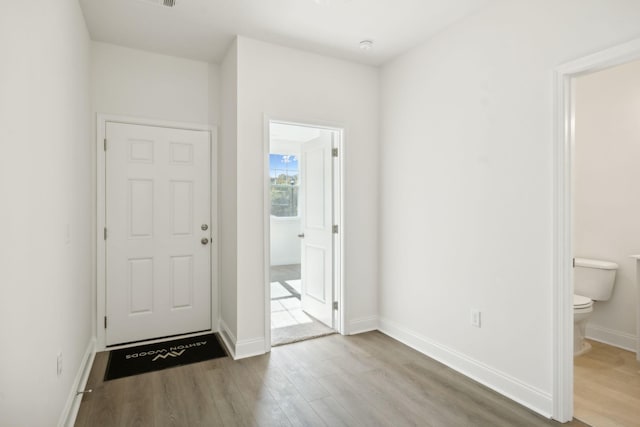 foyer with baseboards and wood finished floors