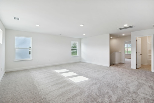 empty room featuring light carpet, visible vents, and recessed lighting