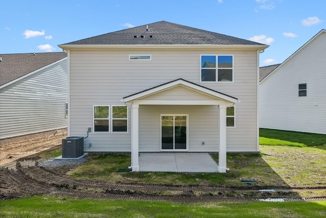 rear view of property with a yard, a patio, a shingled roof, and central air condition unit