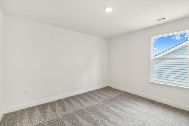 spare room featuring light carpet, recessed lighting, visible vents, and baseboards