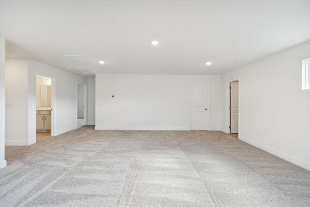 spare room with light carpet, baseboards, and recessed lighting