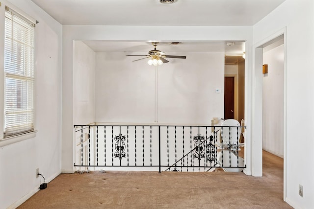 unfurnished room featuring visible vents, baseboards, carpet, and ceiling fan