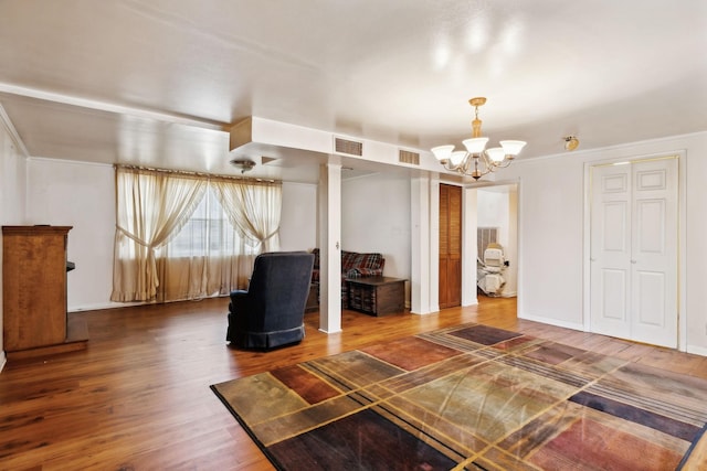 unfurnished bedroom featuring visible vents, an inviting chandelier, and wood finished floors