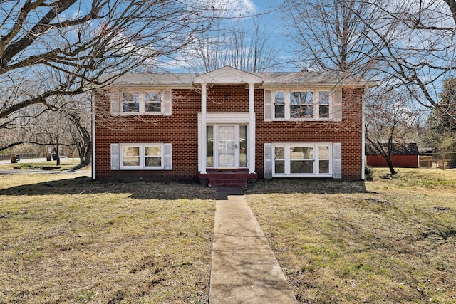 split foyer home featuring entry steps, a front yard, and brick siding