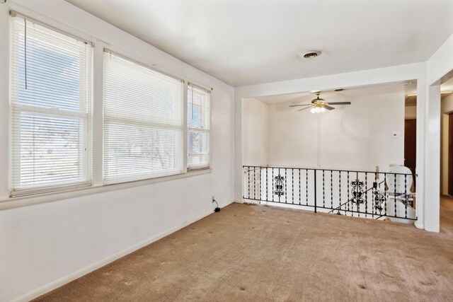 empty room featuring visible vents, baseboards, a ceiling fan, and carpet flooring