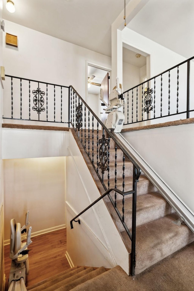 staircase featuring wood finished floors and baseboards