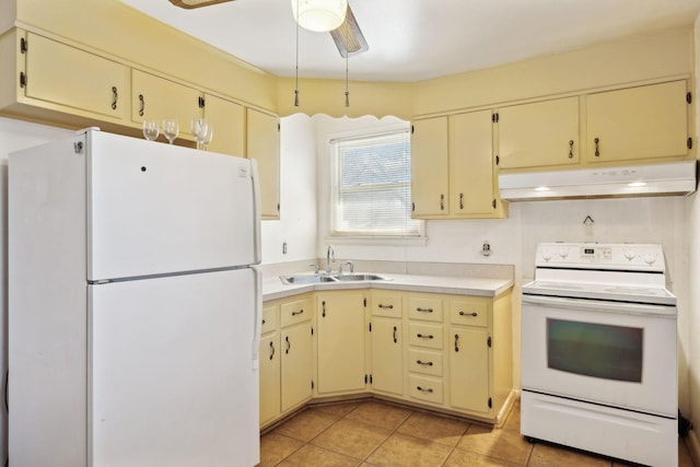 kitchen featuring under cabinet range hood, white appliances, and cream cabinetry