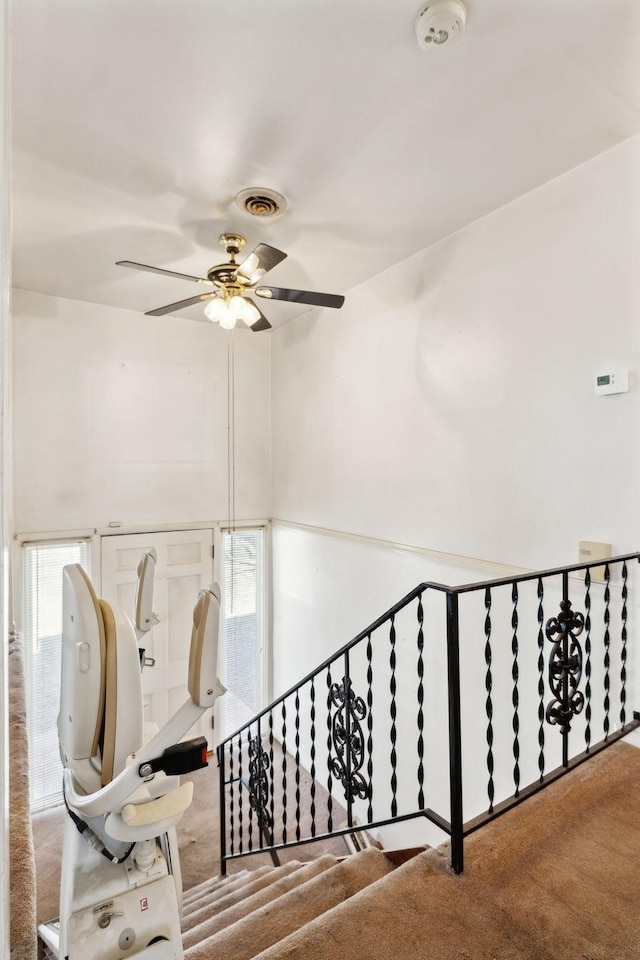 staircase with visible vents and ceiling fan