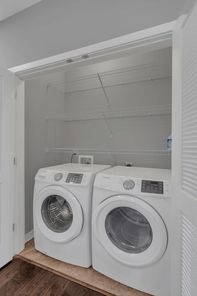 laundry room featuring laundry area, washing machine and clothes dryer, and wood finished floors