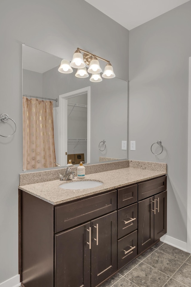 bathroom featuring vanity, baseboards, and tile patterned floors