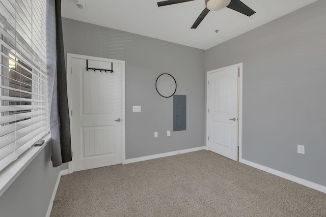 unfurnished bedroom featuring ceiling fan, carpet floors, electric panel, and baseboards