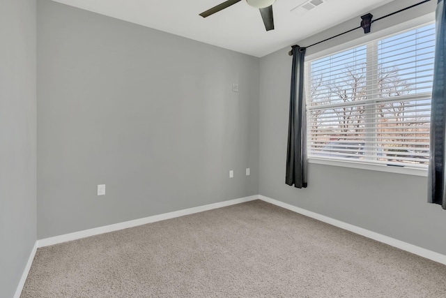 unfurnished room with carpet, visible vents, ceiling fan, and baseboards