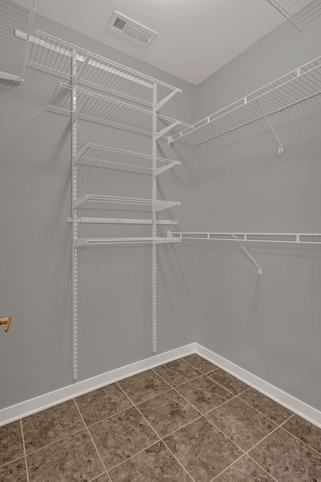 walk in closet with dark tile patterned flooring and visible vents