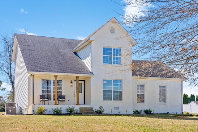 traditional-style home featuring a shingled roof, crawl space, brick siding, and a front lawn