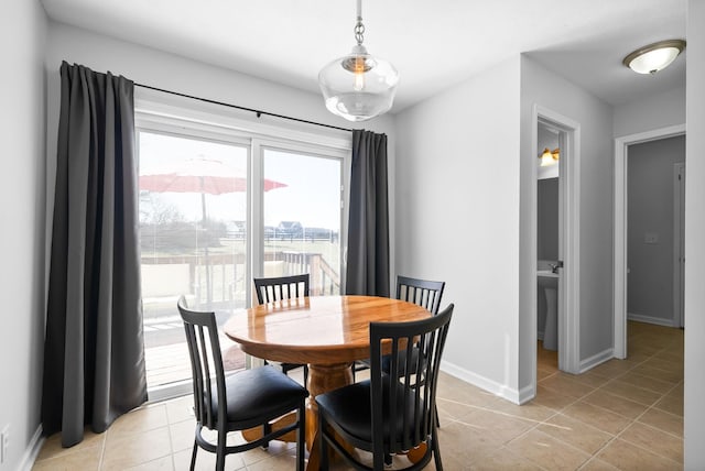 dining area featuring light tile patterned floors and baseboards