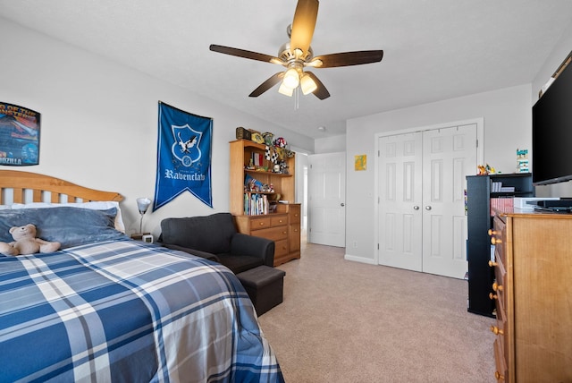 bedroom featuring ceiling fan, a closet, baseboards, and light colored carpet