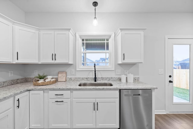 kitchen with a sink, light wood finished floors, white cabinets, and dishwasher