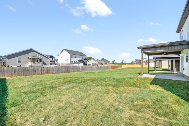 view of yard with a patio area, fence, and a residential view