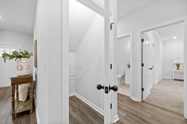 corridor featuring wood finished floors and baseboards