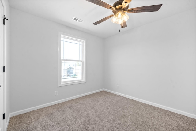 carpeted spare room featuring baseboards, visible vents, and a ceiling fan