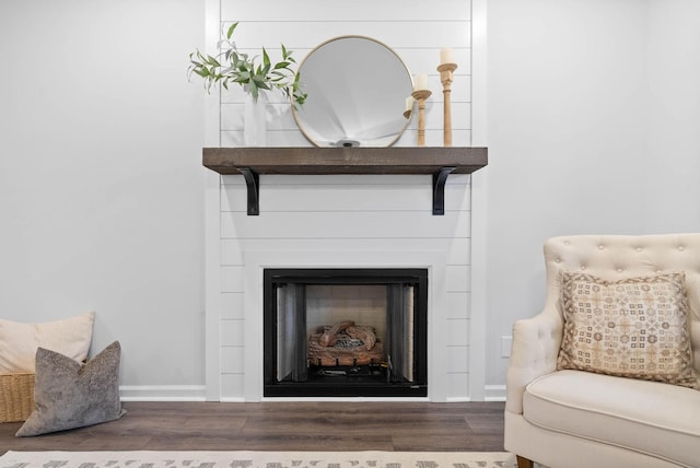 room details with a fireplace, baseboards, and wood finished floors