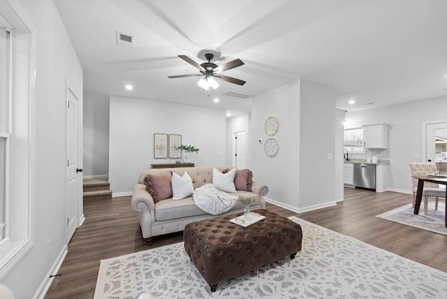 living area featuring recessed lighting, visible vents, dark wood finished floors, and stairway