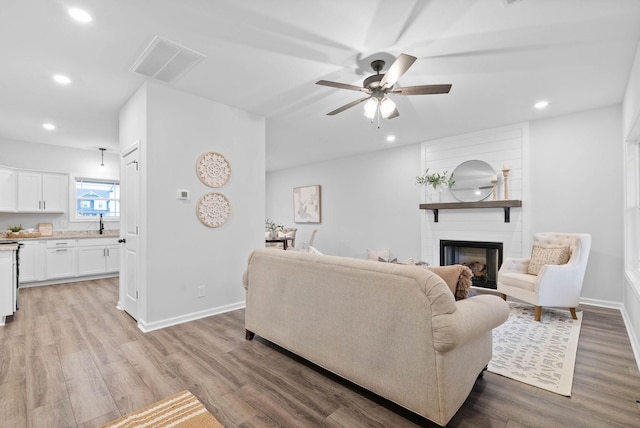 living area with light wood finished floors, baseboards, visible vents, and recessed lighting