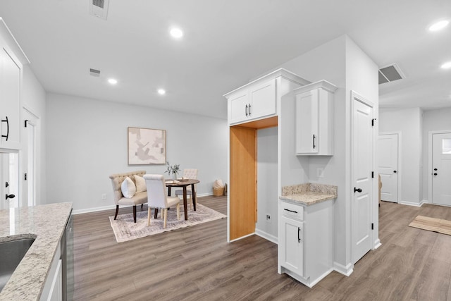 kitchen with white cabinets, wood finished floors, visible vents, and recessed lighting