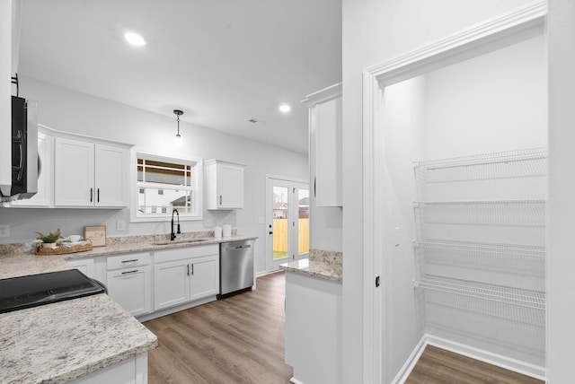 kitchen featuring a sink, light wood-style floors, white cabinets, and dishwasher