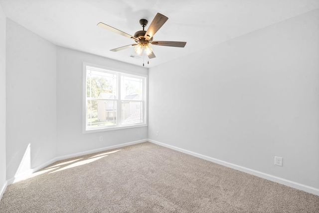 spare room with carpet floors, ceiling fan, and baseboards