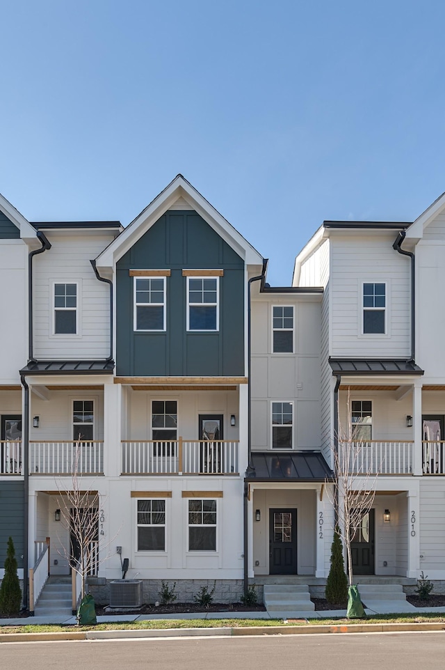 multi unit property featuring a standing seam roof, central AC unit, metal roof, and board and batten siding