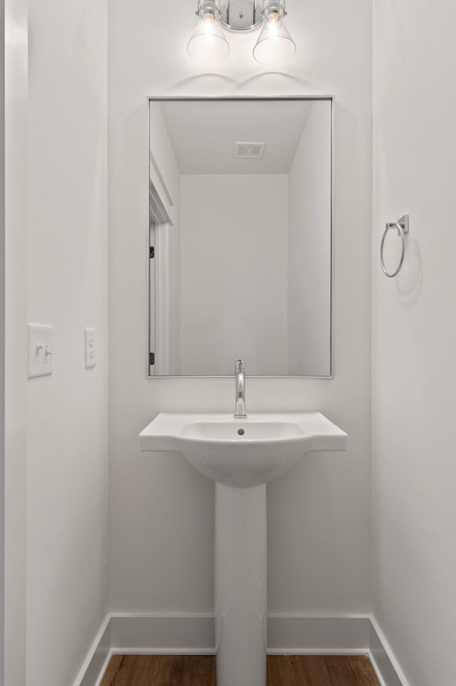 bathroom featuring visible vents, baseboards, and wood finished floors