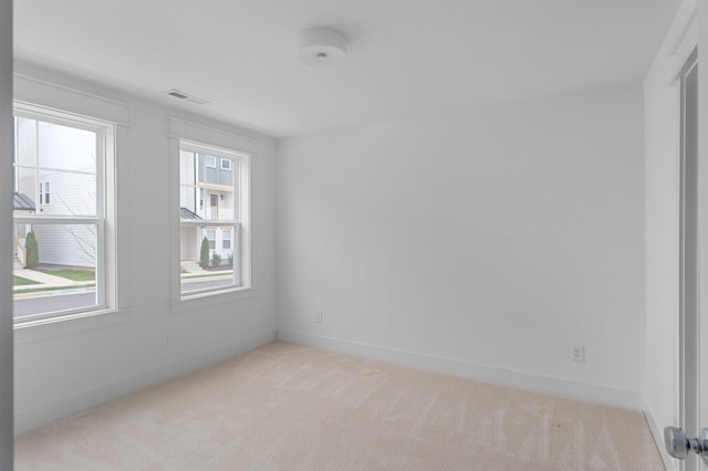 unfurnished room featuring light carpet, visible vents, and baseboards