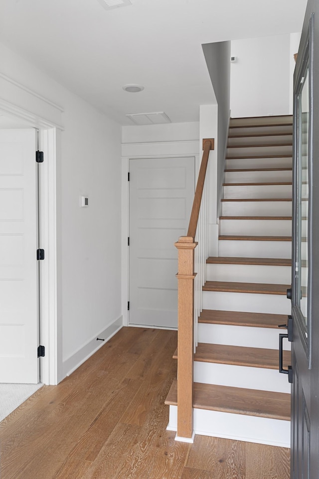 entryway featuring stairs, wood finished floors, and baseboards