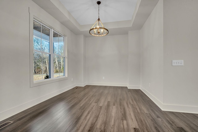 unfurnished room featuring a raised ceiling, visible vents, dark wood finished floors, and baseboards