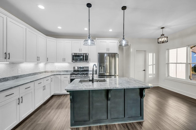 kitchen featuring stainless steel appliances, dark wood finished floors, a sink, and tasteful backsplash