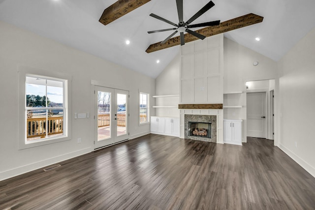 unfurnished living room featuring beam ceiling, a fireplace, visible vents, and a healthy amount of sunlight