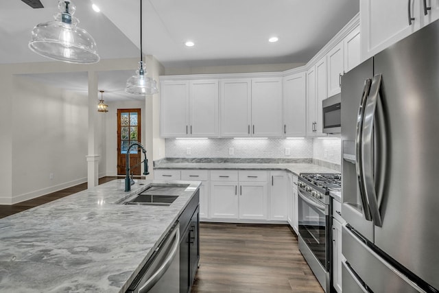 kitchen featuring appliances with stainless steel finishes, a sink, white cabinetry, and light stone countertops