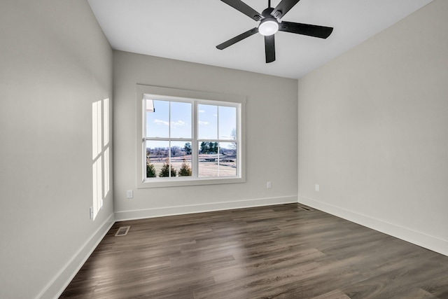 unfurnished room with dark wood-style floors, ceiling fan, visible vents, and baseboards