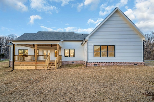 rear view of property featuring a shingled roof, crawl space, and a wooden deck