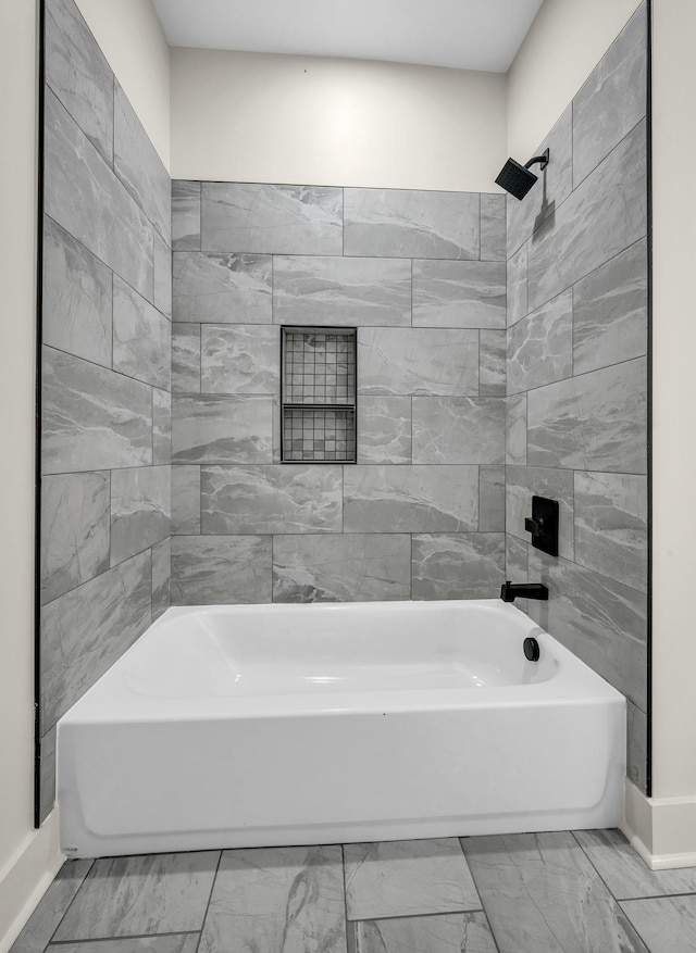 bathroom featuring marble finish floor,  shower combination, and baseboards