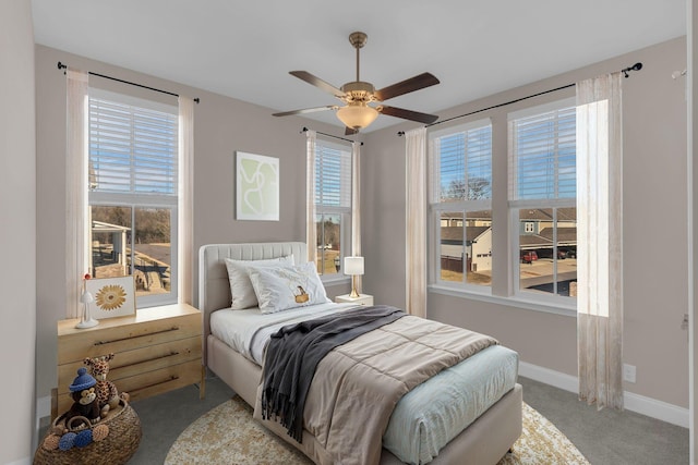 carpeted bedroom featuring baseboards and ceiling fan