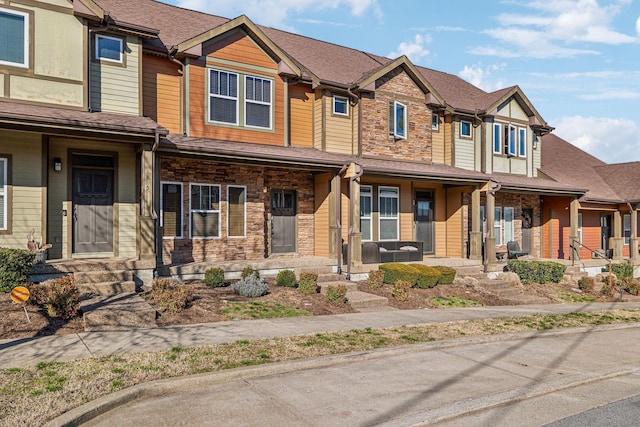 view of property with a porch and stone siding