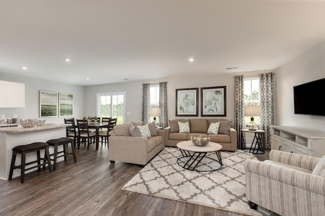 living room featuring a healthy amount of sunlight, dark wood finished floors, and recessed lighting