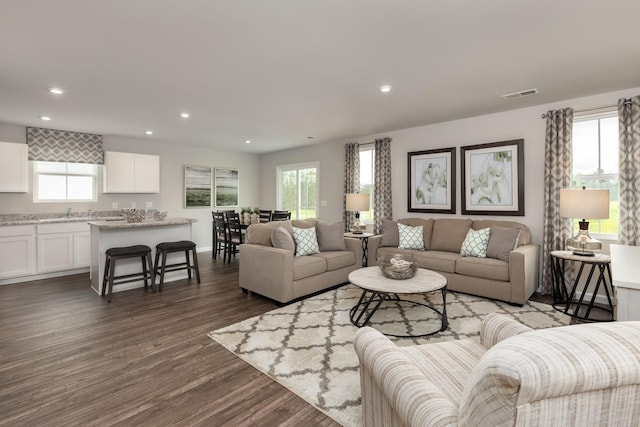 living area with plenty of natural light, visible vents, dark wood finished floors, and recessed lighting