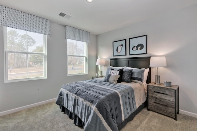 bedroom with baseboards, visible vents, and light colored carpet