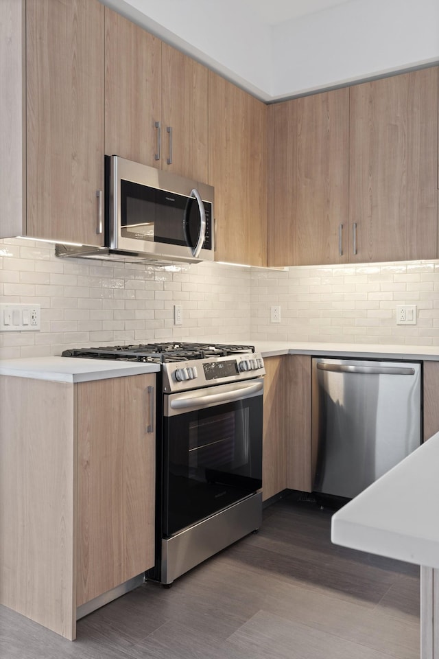 kitchen featuring light countertops, modern cabinets, light brown cabinets, and appliances with stainless steel finishes