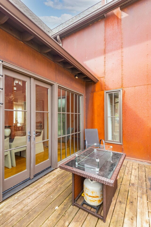 wooden terrace with french doors and outdoor dining area