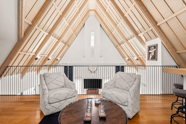 living area with vaulted ceiling and wood finished floors