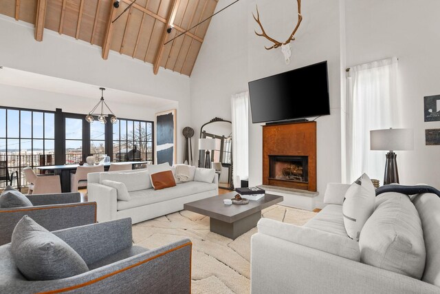 living room featuring wooden ceiling, high vaulted ceiling, and a fireplace with raised hearth